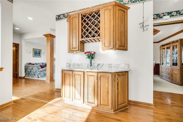 bar featuring baseboards, ornate columns, recessed lighting, light wood-style floors, and indoor bar