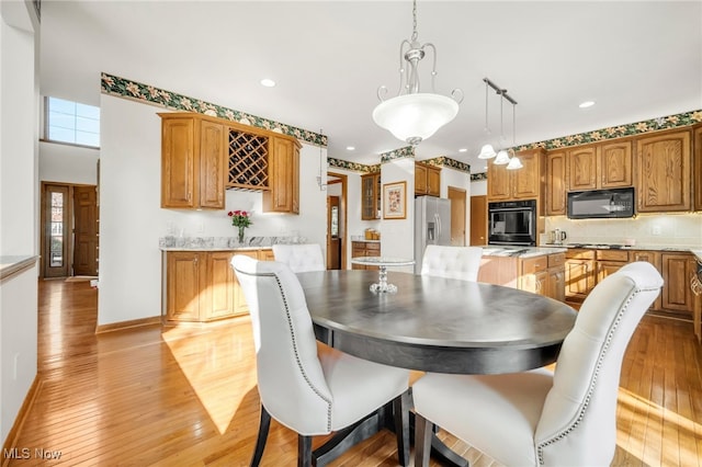 dining room featuring recessed lighting, baseboards, and light wood finished floors