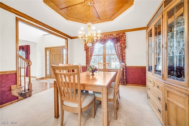 dining area with crown molding, stairs, a tray ceiling, light carpet, and a notable chandelier