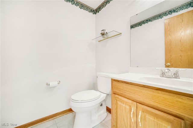 half bathroom with tile patterned flooring, toilet, vanity, and baseboards