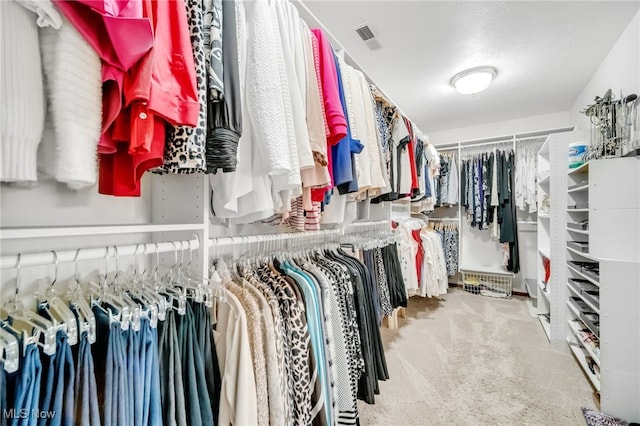 walk in closet featuring visible vents and carpet floors