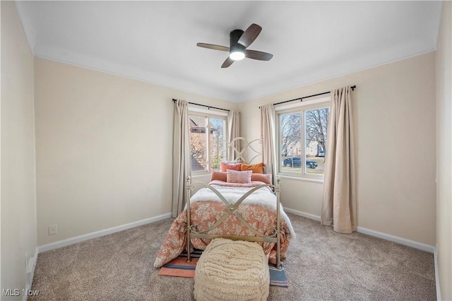 carpeted bedroom featuring ornamental molding, baseboards, and ceiling fan