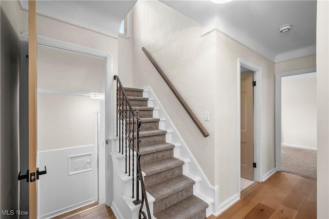 stairway with baseboards and wood finished floors