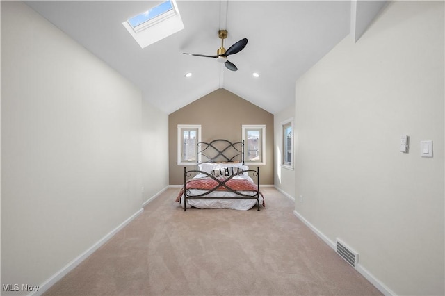 bedroom featuring lofted ceiling with skylight, baseboards, visible vents, and light carpet