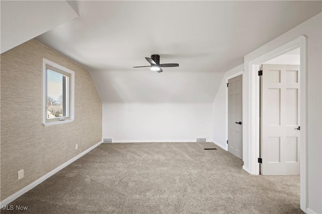 bonus room with visible vents, lofted ceiling, and carpet