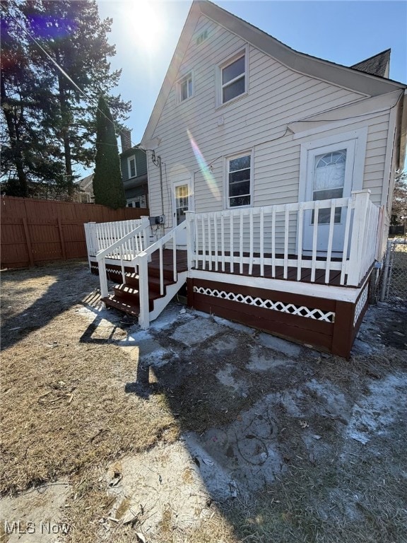 rear view of house featuring fence and a wooden deck