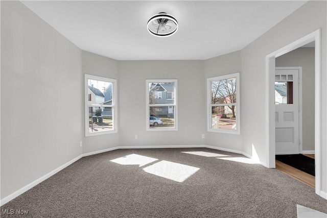 carpeted empty room with baseboards and plenty of natural light