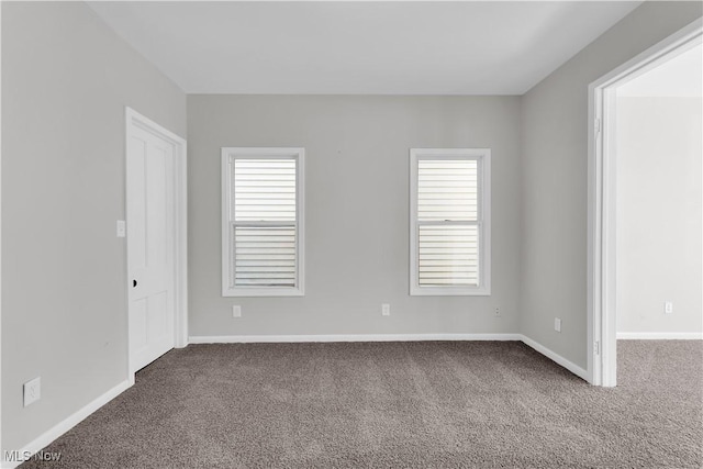 unfurnished room featuring baseboards and carpet