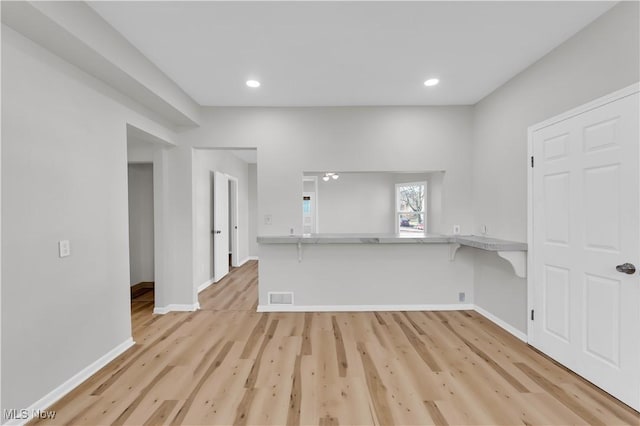 empty room featuring recessed lighting, light wood-style floors, visible vents, and baseboards