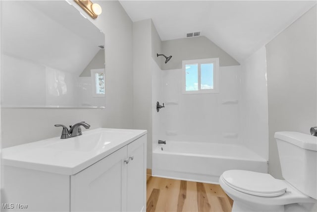 full bathroom featuring visible vents, toilet, wood finished floors, and vaulted ceiling