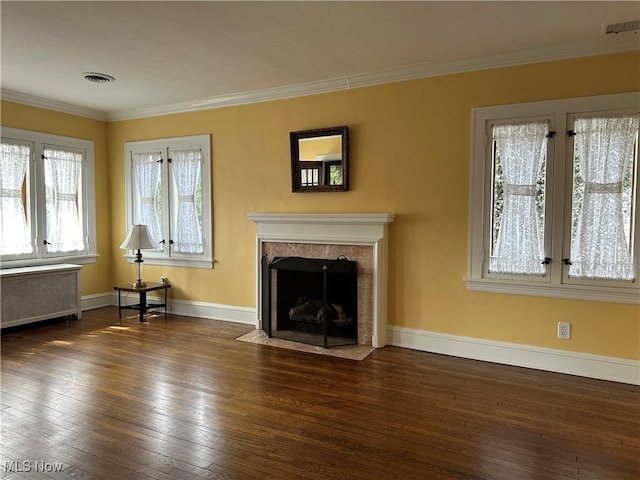 unfurnished living room with a premium fireplace, radiator heating unit, dark wood-style floors, and ornamental molding