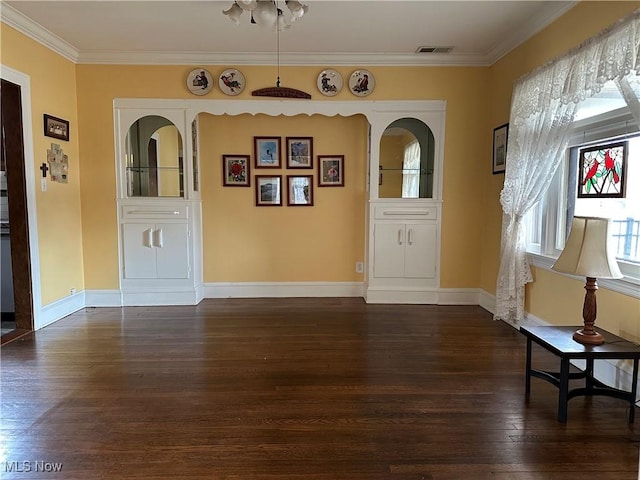 entrance foyer with visible vents, baseboards, dark wood-type flooring, and crown molding