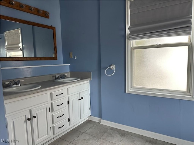 bathroom with double vanity, a healthy amount of sunlight, and a sink