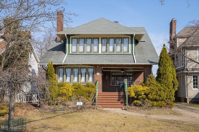 view of front of house featuring brick siding, a porch, a shingled roof, and ceiling fan