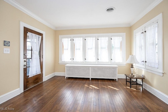 foyer entrance with a wealth of natural light, visible vents, radiator, and dark wood-style flooring