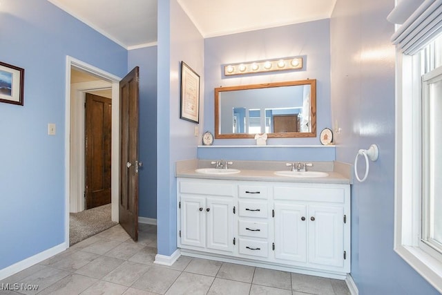 full bath featuring a sink, baseboards, double vanity, and crown molding