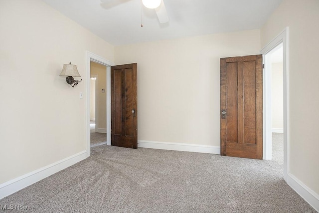 carpeted empty room with ceiling fan and baseboards