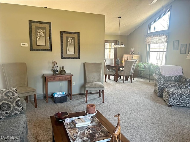 carpeted living room featuring a wealth of natural light, a chandelier, baseboards, and lofted ceiling