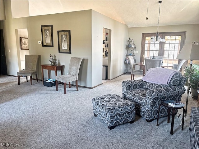 living area with light carpet, a chandelier, baseboards, and vaulted ceiling