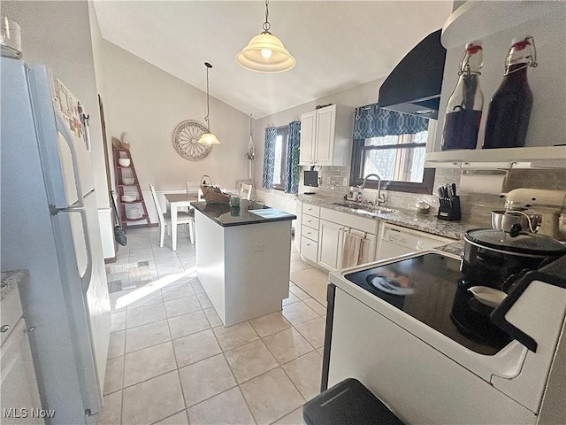 kitchen with tasteful backsplash, a center island, lofted ceiling, white appliances, and a sink