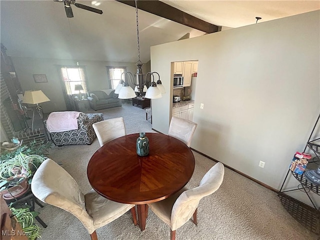 dining area with ceiling fan with notable chandelier, lofted ceiling with beams, light colored carpet, and baseboards