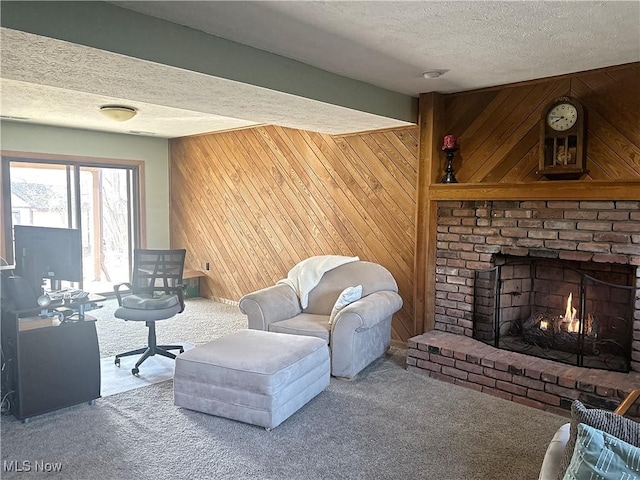 living area featuring a brick fireplace, carpet flooring, wood walls, and a textured ceiling