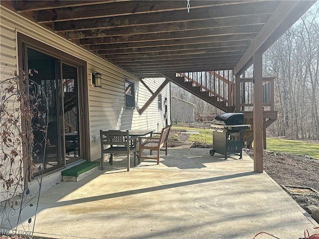 view of patio featuring stairs, area for grilling, and outdoor dining space