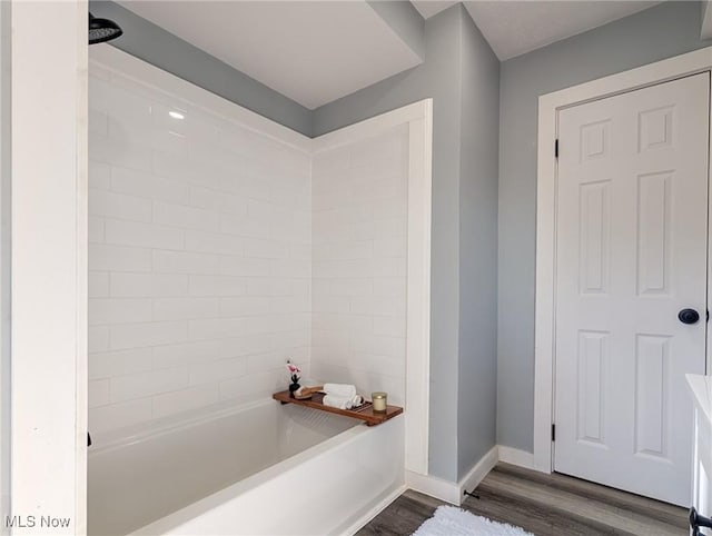 full bathroom featuring bathing tub / shower combination, wood finished floors, and baseboards