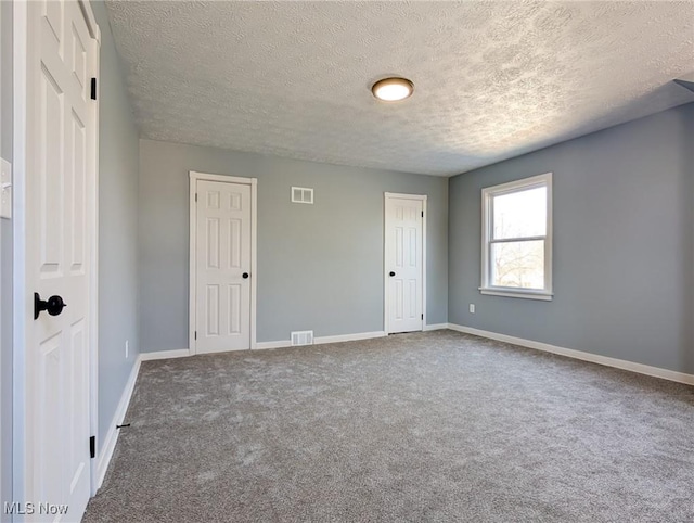 unfurnished bedroom with visible vents, baseboards, and carpet