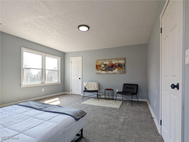 carpeted bedroom with a textured ceiling and baseboards