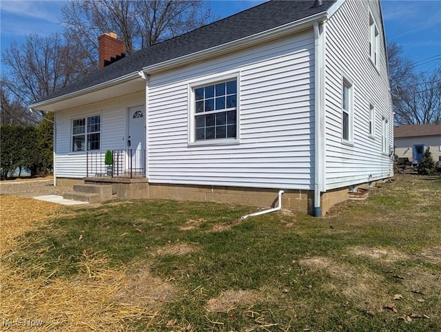 view of front facade with a front yard and a chimney