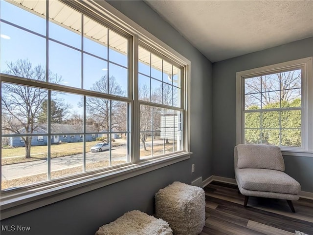 sitting room featuring plenty of natural light, dark wood-style floors, baseboards, and a textured ceiling