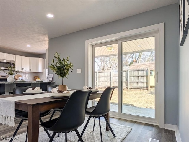 dining room with light wood-style flooring, recessed lighting, and baseboards