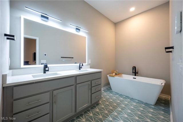 bathroom featuring a sink, a freestanding tub, recessed lighting, and double vanity