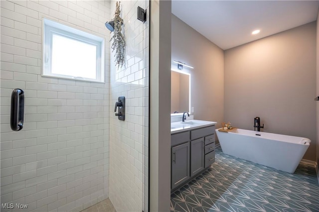 bathroom featuring recessed lighting, a shower stall, a freestanding bath, and vanity