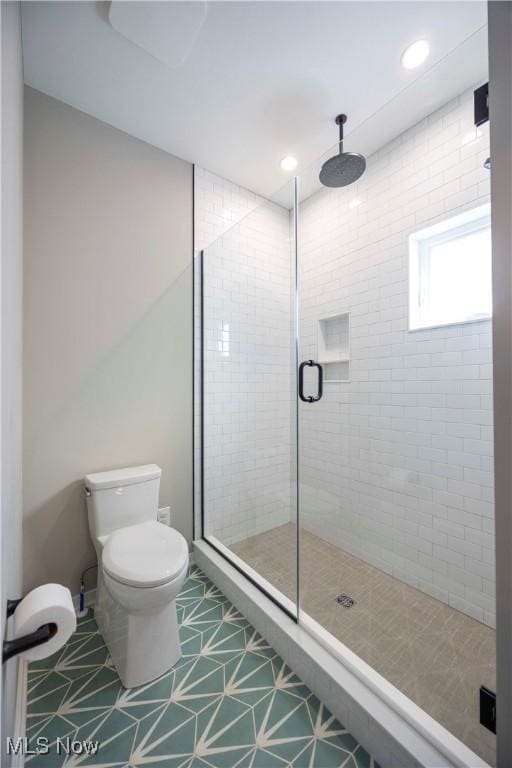 bathroom featuring tile patterned floors, toilet, recessed lighting, and a shower stall