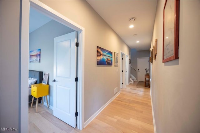 hall featuring recessed lighting, light wood-type flooring, and baseboards