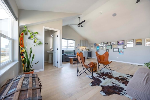 dining room with light wood-style flooring, baseboards, a ceiling fan, and vaulted ceiling