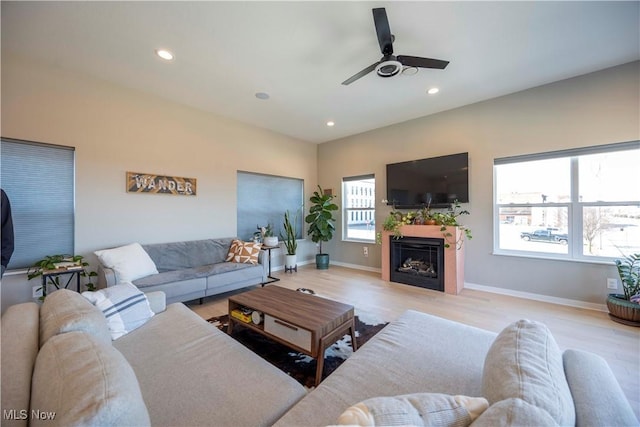 living area with recessed lighting, baseboards, light wood-style floors, and a fireplace