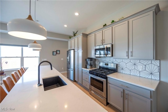 kitchen featuring gray cabinets, appliances with stainless steel finishes, and a sink