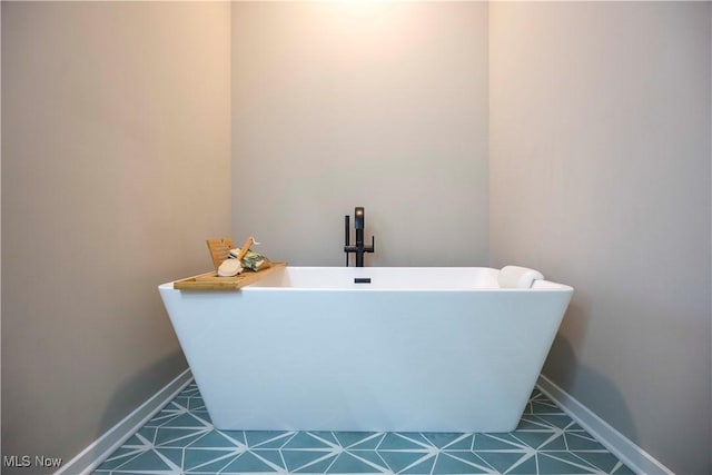 bathroom with baseboards and a soaking tub