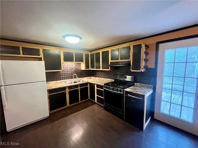 kitchen with stainless steel gas range, backsplash, freestanding refrigerator, and a sink