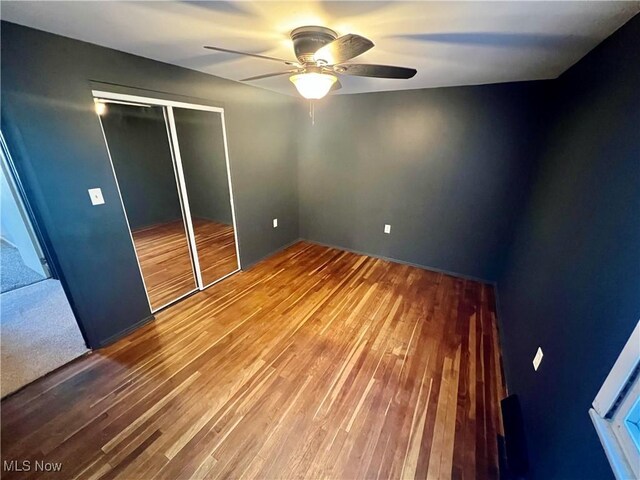 unfurnished bedroom with a closet, ceiling fan, and wood finished floors