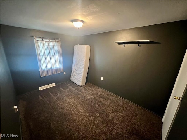 unfurnished bedroom featuring visible vents and carpet floors