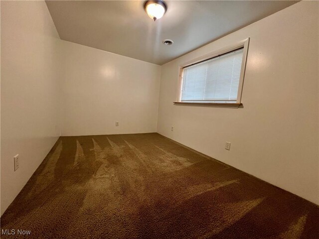 empty room featuring visible vents and carpet floors