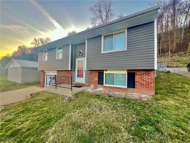 bi-level home with a yard and brick siding