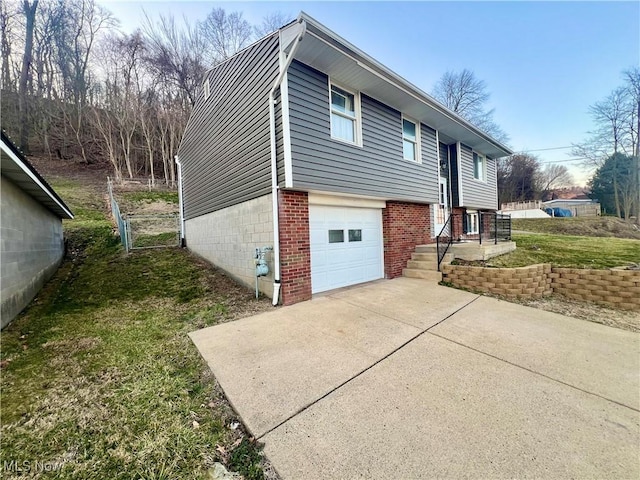 view of side of home featuring a yard, driveway, and a garage