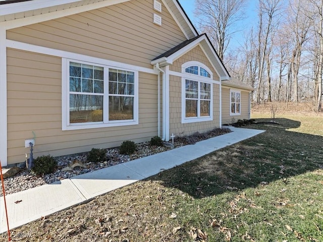 view of property exterior featuring a lawn