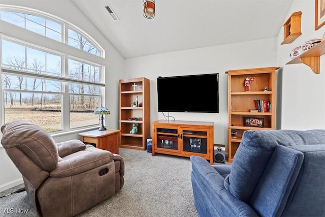 living area featuring vaulted ceiling, visible vents, and carpet floors