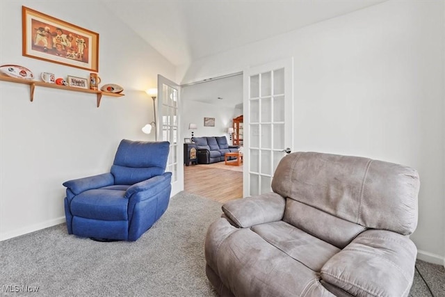 living area featuring carpet flooring, french doors, baseboards, and vaulted ceiling